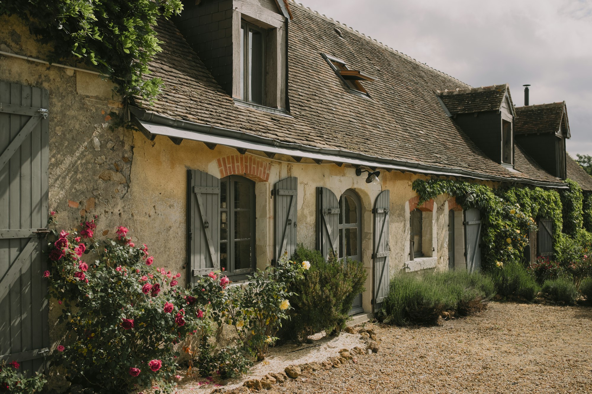 Maison en pierre entourée d’un jardin fleuri